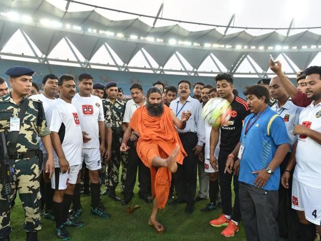 Indian yoga guru Baba Ramdev kicks a football ahead of a charitable football match between Indian Bollywood actors and Indian Parliamentarians in New Delhi on July 24, 2016.  (AFP) 