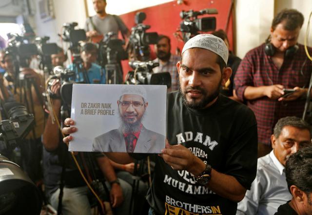A man holds a book featuring Zakir Naik before a video conference by Naik, in Mumbai. (REUTERS File) A man holds a book featuring Zakir Naik before a video conference by Naik, in Mumbai. (REUTERS File)
