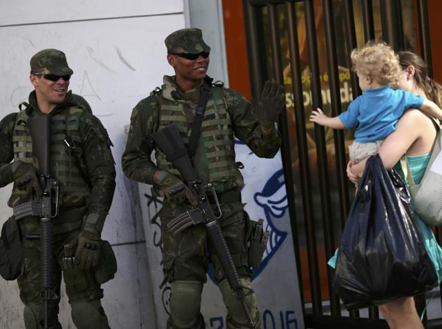 Brazilian soldiers greet a child on the first day of a massive security operation that they say will last through the end of the Rio 2016 Olympic Games. (REUTERS Photo)