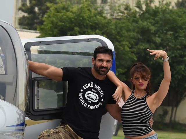 John Abraham and Jacqueline Fernandez pose with the helicopter during a promotional event of their Dishoom. (AFP)