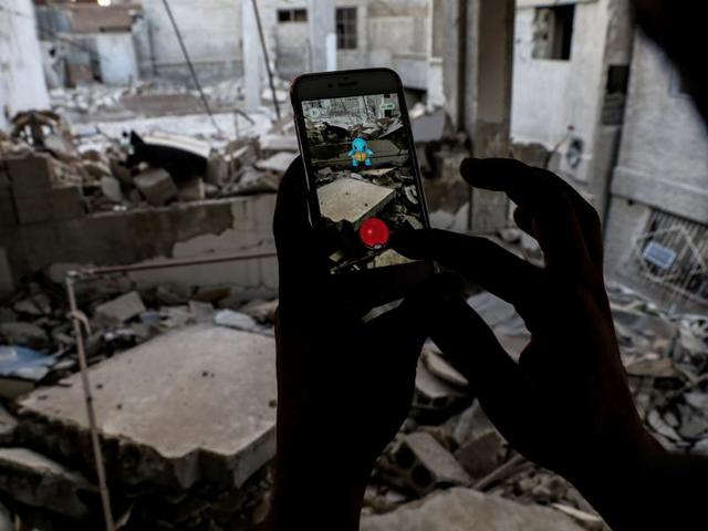 A Syrian gamer catches a Pokemon amid the rubble in the besieged rebel-controlled town of Douma, a flashpoint of the conflict, east of the Syrian capital Damascus. (AFP) A Syrian gamer catches a Pokemon amid the rubble in the besieged rebel-controlled town of Douma, a flashpoint of the conflict, east of the Syrian capital Damascus. (AFP)