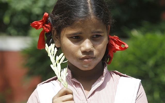 A girl holds flowers as children wait to pay tribute to Kalam as his body is transported from the airport to his house in New Delhi on July 28, 2015 (Ravi Choudhary/HT Photo)