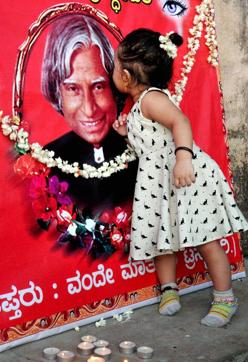 A child kisses former president Kalam’s photo in Karnataka’s Chikmagalur on July 29, 2015. (PTI Photo)
