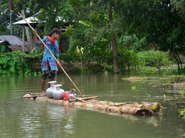 A girl pushes a banana raft in search of drinking water at Alikakh village in South Kamrup district of Assam on Monday. (PTI Photo)