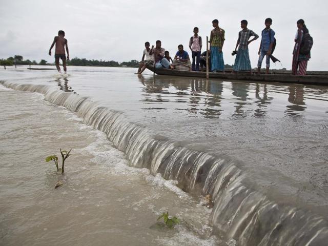 Villagers on a boat move through a submerged road after heavy monsoon rains flooded Gagalmari village. (AP Photo)