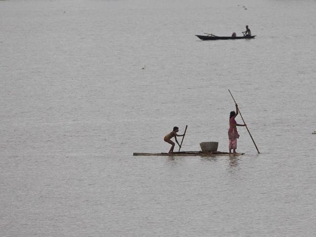 Villagers on a makeshift banana raft after heavy monsoon rains flooded Burhaburhi village. (AP Photo)