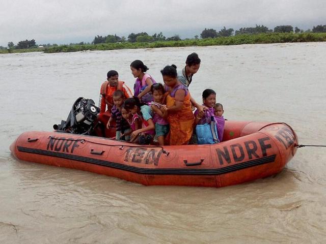 Disaster Response Force(NDRF) jawans rescue flood affected villagers , at Chirang district in Assam on Tuesday. (PTI Photo)