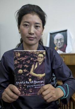 Nyima Lhamo, 26, holds a book with a portrait of her uncle Tenzin Delek Rinpoche. (AP) Nyima Lhamo, 26, holds a book with a portrait of her uncle Tenzin Delek Rinpoche. (AP)