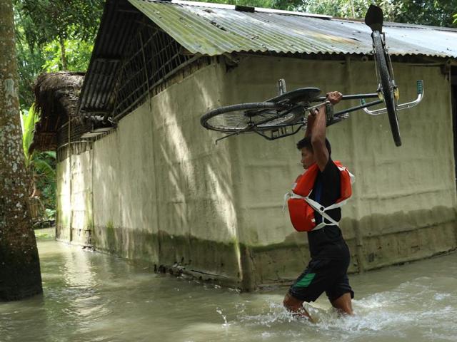 A Mishing tribal man carries grass for his cattle on a boat surrounded by flood waters at Majuli, Assam, Wednesday, July 27, 2016. Heavy rains and floods have affected over 20 lakh people in the state.(AP)