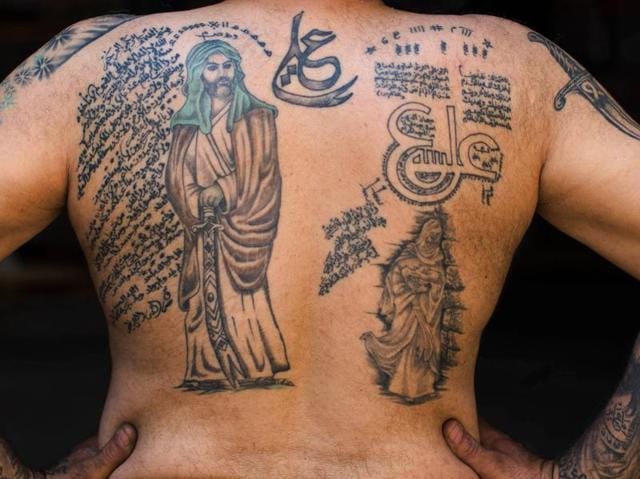 Ali Hussein Nasreddine, 50, poses for a photo showing off his tattoos, one of which is that of Imam Ali. (AP) 