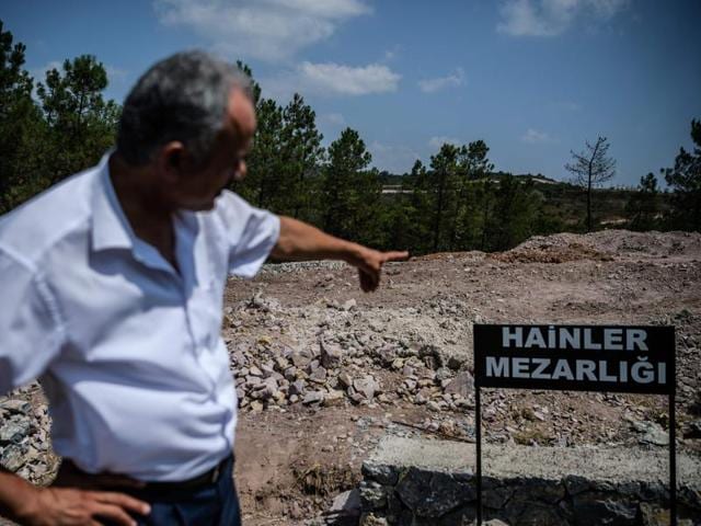 A man points a sign reading in Turkish language "Traitors' Cemetery" is seen in front of unmarked graves built specially by Istanbul municipality for the dead failed coup solders at Pendik district in Istanbul.(AFP) A man points a sign reading in Turkish language "Traitors' Cemetery" is seen in front of unmarked graves built specially by Istanbul municipality for the dead failed coup solders at Pendik district in Istanbul.(AFP)