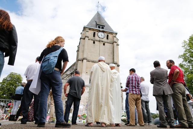 Muslims put flowers and hold a minute of silence on July 29, 2016 in front of the church if Saint-Etienne-du-Rouvray, western France, where French priest Jacques Hamel waskilled on July 26. (AFP) Muslims put flowers and hold a minute of silence on July 29, 2016 in front of the church if Saint-Etienne-du-Rouvray, western France, where French priest Jacques Hamel waskilled on July 26. (AFP)