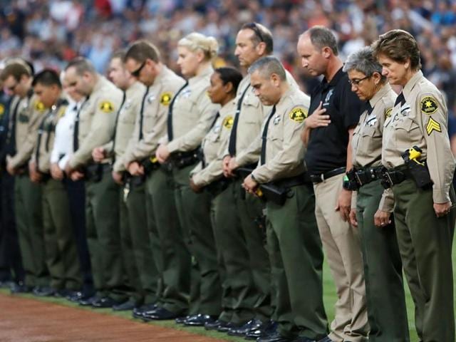 San Diego county sheriff's department officers stand in memory of officer Jonathan DeGuzman with a moment of silence before a baseball game on Friday. (AP) San Diego county sheriff's department officers stand in memory of officer Jonathan DeGuzman with a moment of silence before a baseball game on Friday. (AP)