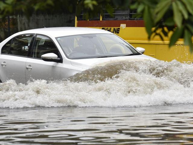 A car driver finds his way through a waterlogged street on Friday. (Vijayanand Gupta/HT) A car driver finds his way through a waterlogged street on Friday. (Vijayanand Gupta/HT)