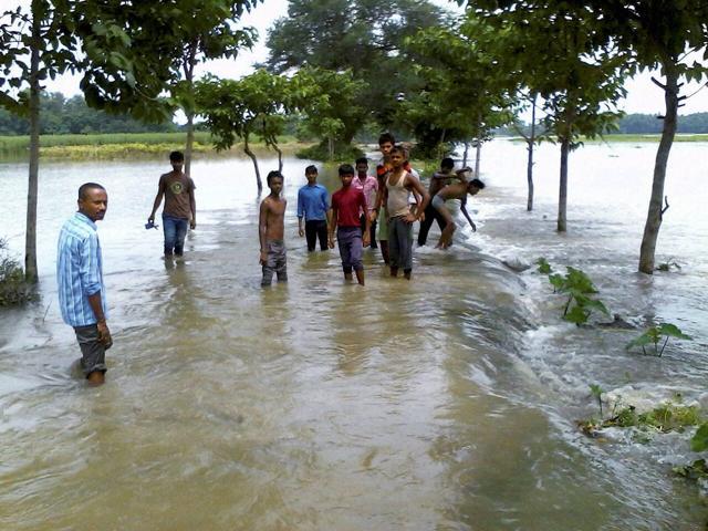 Villagers try to cross a flooded road in Katihar district of Bihar on Saturday. (PTI Photo) Villagers try to cross a flooded road in Katihar district of Bihar on Saturday. (PTI Photo)