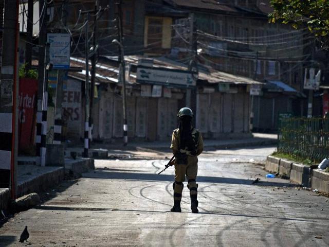 A soldier stands guard during curfew in Srinagar on Friday. (PTI) A soldier stands guard during curfew in Srinagar on Friday. (PTI)