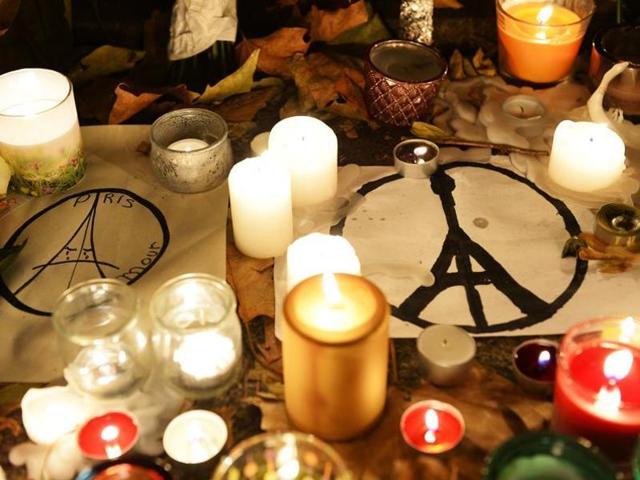 This photo taken on November 16, 2015 shows candles and messages left at a makeshift memorial next to the Bataclan concert hall in Paris. Islamic State jihadists claimed a series of coordinated attacks by gunmen and suicide bombers in Paris that killed at least 129 people.(AFP)