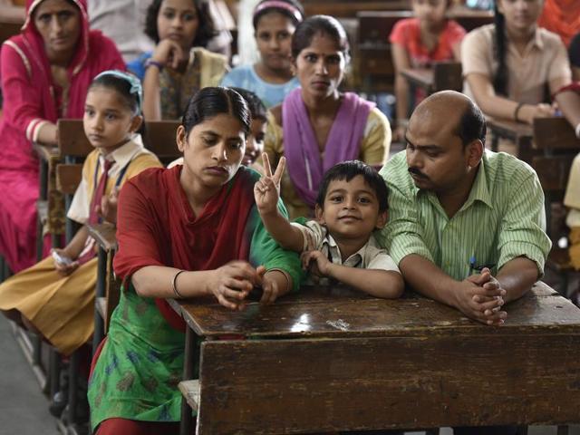 A boy sits in a classroom with his parents to meet teachers during the parent-teacher meeting at the Government Sarvodya Secondary School in Jorbagh, New Delhi. (Raj K Raj/HT PHOTO) A boy sits in a classroom with his parents to meet teachers during the parent-teacher meeting at the Government Sarvodya Secondary School in Jorbagh, New Delhi. (Raj K Raj/HT PHOTO)