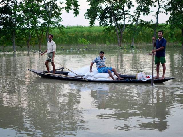 Villagers carry flood relief items on a country boat in flood-affected Pasahbari, near Guwahati, in Assam. (PTI Photo) Villagers carry flood relief items on a country boat in flood-affected Pasahbari, near Guwahati, in Assam. (PTI Photo)