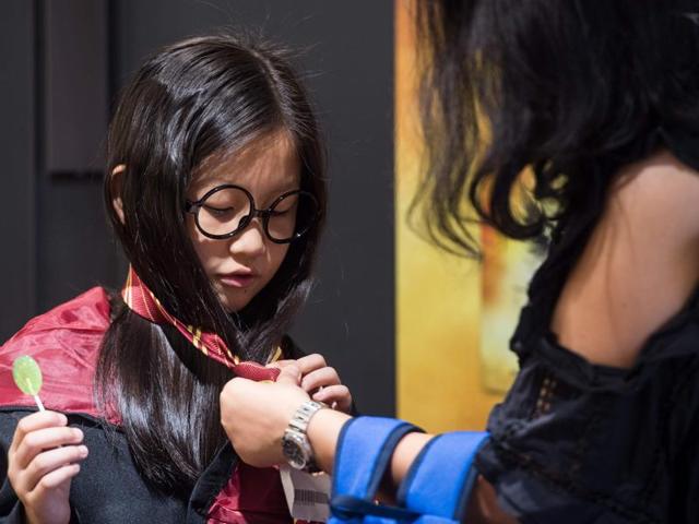 A mother helping her daughter get dressed as a Harry Potter character in Hong Kong. (AFP) A mother helping her daughter get dressed as a Harry Potter character in Hong Kong. (AFP)
