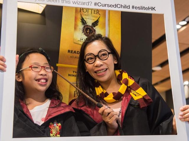 A mother and her daughter pose dressed up as Harry Potter characters in front of a poster at a bookstore in Hong Kong. (AFP) A mother and her daughter pose dressed up as Harry Potter characters in front of a poster at a bookstore in Hong Kong. (AFP)