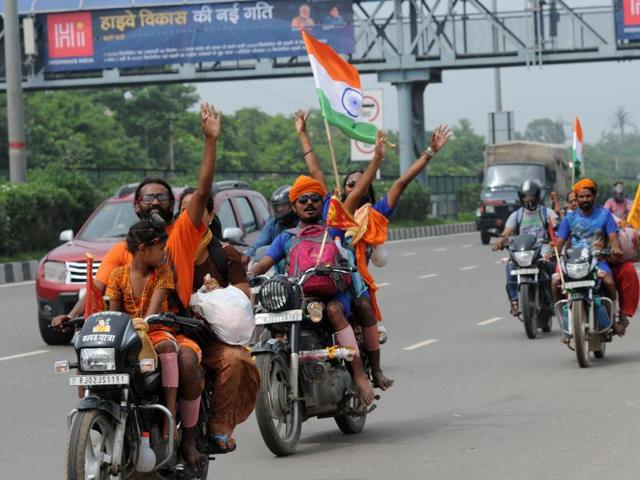 The ‘dak kanwarias’ run a relay race where one pilgrim completes a fixed distance and then hands over the pot containing water from river Ganga to another member of the same group also hit the roads, including NH-8, in large numbers. (Parveen Kumar/HT Photo) The ‘dak kanwarias’ run a relay race where one pilgrim completes a fixed distance and then hands over the pot containing water from river Ganga to another member of the same group also hit the roads, including NH-8, in large numbers. (Parveen Kumar/HT Photo)