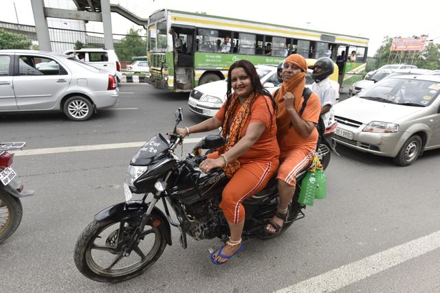 Kanwarias carrying holy water are seen on a bike at NH24 in New Delhi. (Virendra Singh Gosain/HT PHOTO) Kanwarias carrying holy water are seen on a bike at NH24 in New Delhi. (Virendra Singh Gosain/HT PHOTO)