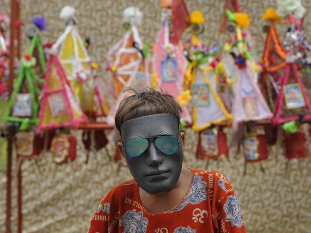 A Kanwaria wears a mask as he poses for a photograph at a resting camp, in Noida. (Burhaan Kinu/HT Photo) A Kanwaria wears a mask as he poses for a photograph at a resting camp, in Noida. (Burhaan Kinu/HT Photo)