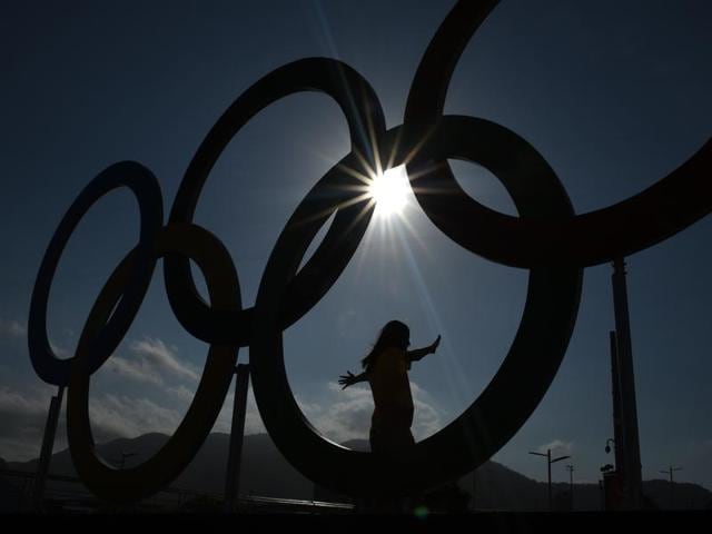 A woman is silhouetted as she poses with the Olympic rings at the Olympic park. (AFP Photo) A woman is silhouetted as she poses with the Olympic rings at the Olympic park. (AFP Photo)