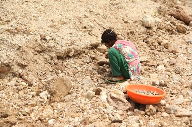 Thirteen-year-old Gudiya breaks away pieces of mica from rocks in an illegal open-cast mine in Koderma district of Jharkhand on June 29, 2016. (Nita Bhalla, Thomson Reuters Foundation)