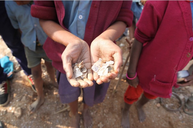 A girl shows mica flakes she has collected while working in an open-cast illegal mine in Giridih district of Jharkhand on January 22, 2016. (Nita Bhalla, Thomson Reuters Foundation)