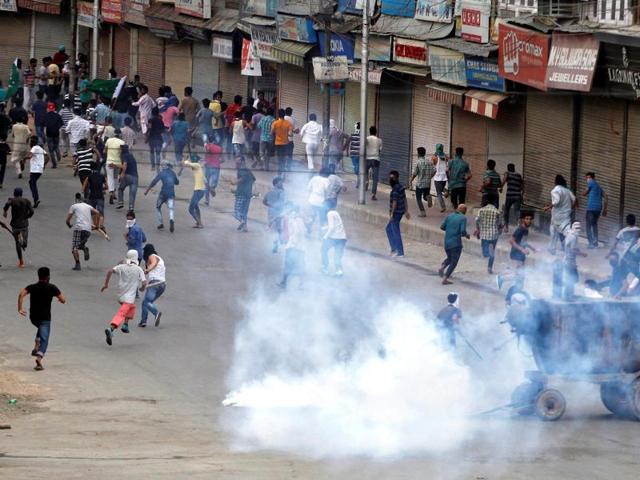 Smoke billows from a tear gas shell fired by Indian police as demonstrators run for cover during a protest in Srinagar. (Reuters File Photo)