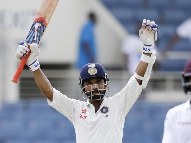 Ajinkya Rahane, centre, celebrates after he scored a century as teammate Umesh Yadav, left, congratulates him during day three of their second cricket Test match at the Sabina Park Cricket Ground in Kingston, Jamaica, on Monday.(AP)
