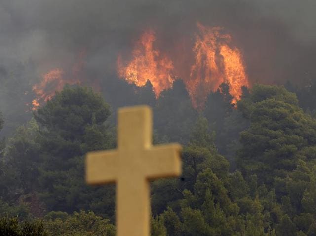 Nearly 200 firemen, assisted by water-dropping aircraft, fire engines and volunteers, are fighting a large forest fire that has raged through the Greek island of Evia. (AP Photo) Nearly 200 firemen, assisted by water-dropping aircraft, fire engines and volunteers, are fighting a large forest fire that has raged through the Greek island of Evia. (AP Photo)