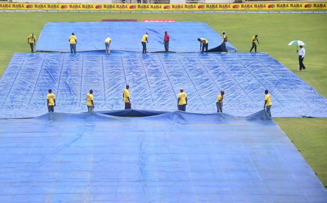 Groundskeepers cover the pitch due to rain in the afternoon on day three of Second Test cricket match (AFP)