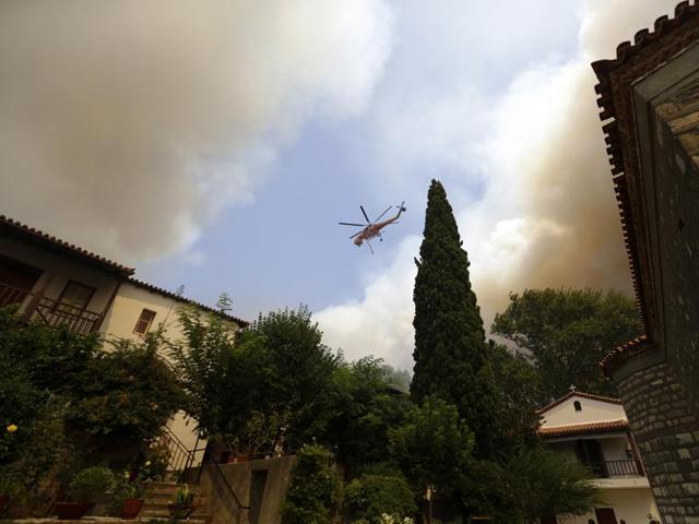 An helicopter operates over a fire next to Galataki Monastery near the seaside village of Limni. (AP Photo) An helicopter operates over a fire next to Galataki Monastery near the seaside village of Limni. (AP Photo)