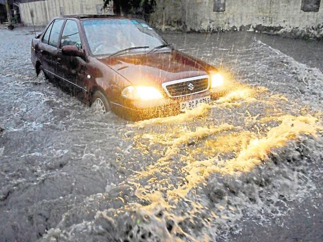 Heavy rain caused massive waterlogging and resulted in snarls as several traffic lights were on the blink.(Burhaan Kinu/HT Photo)