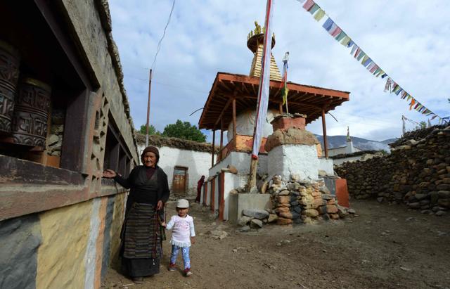 A Nepalese woman spins prayer wheels as she walks home. Hardly any young men are left in the country as they seek better paying jobs abroad, mostly in the Middle East. (AFP Photo) A Nepalese woman spins prayer wheels as she walks home. Hardly any young men are left in the country as they seek better paying jobs abroad, mostly in the Middle East. (AFP Photo)