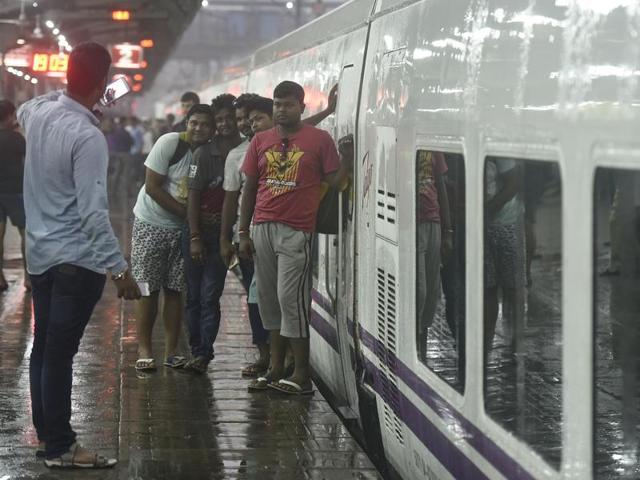 The train was delayed between Surat-Mumbai section as the tracks were washed away due to floods. But that did not stop onlookers from posing for pictures with the swanky white trains with purple stripes.     (Raj K Raj/HT PHOTO) 