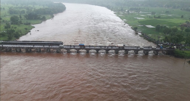 An aerial view of the bridges running across the Savitri river. Two bridges connect the river banks -- the collapsed bridge was an old, British era structure, while the standing bridge is a more recent construction. Traffic has been redirected on to the new bridge. (Presley Thomas/HT Photo)