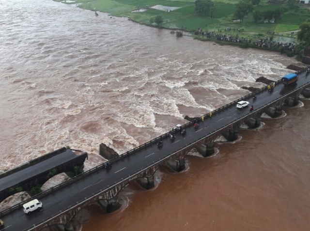 An old bridge connecting to the Mumbai-Goa highway collapsed and was washed away by the Savitri river late on Tuesday night. Authorities believe 10 vehicles might have fallen into the river.(HT Photo)