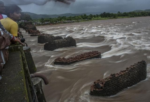 People watch as the search and rescue operation is going on after an old bridge connecting to the Mumbai-Goa highway collapsed and was washed away by the Savitri river late on Tuesday night in Mahad, India. (Satish Bate)