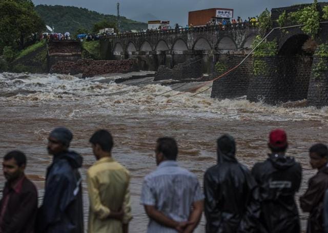 People watch as the search and rescue operation is going on after an old bridge connecting to the Mumbai-Goa highway collapsed and was washed away by the Savitri river late on Tuesday night in Mahad, India. (Satish Bate)