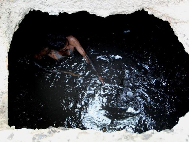 A sanitation worker cleans a sewage drain in Mumbai.(Praful Gangurde/ Hindustan Times File)