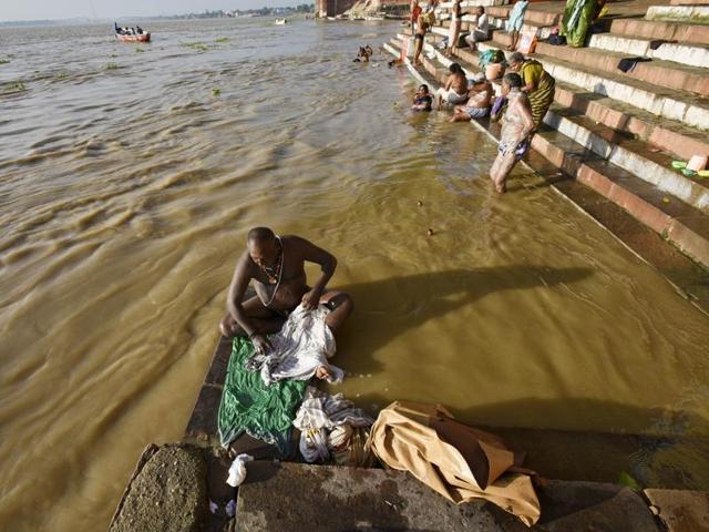 Locals bath and wash clothes at Harishchandra Ghat on the River Ganges in Varanasi. 1.1 million of human excrements is discharged into the Ganga every minute. (Ravi Choudhary/HT PHOTO)