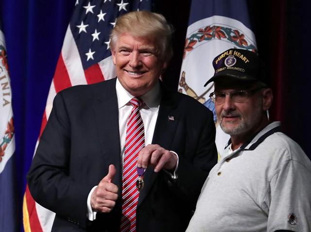 Republican presidential nominee Donald Trump, left, greets veteran Louis Dorfman, who gave him his Purple Heart during a campaign event in Ashburn, Virginia. (AFP) Republican presidential nominee Donald Trump, left, greets veteran Louis Dorfman, who gave him his Purple Heart during a campaign event in Ashburn, Virginia. (AFP)