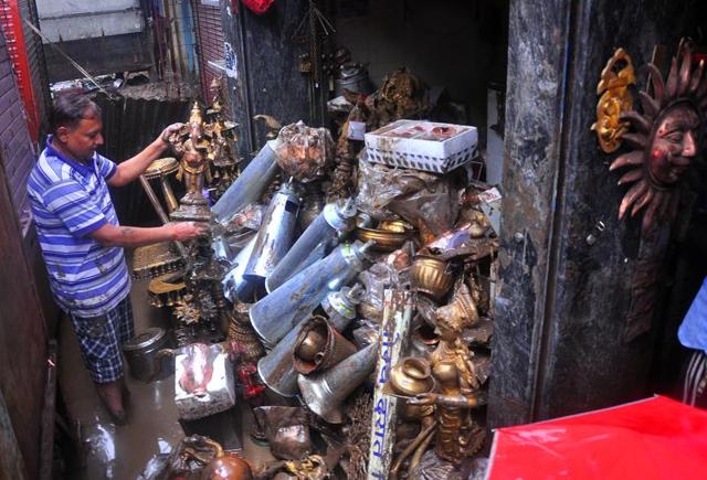 A man sorts out flood damaged materials after flood water recedes from locality caused by heavy rain in Nashik, India, on Tuesday.
