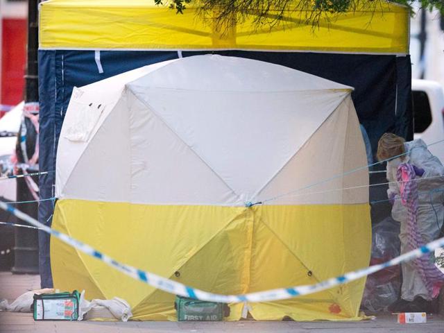A police forensic officer (right) works in Russell Square in London. (AFP Photo)