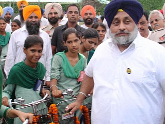 Deputy CM Sukhbir Singh Badal posing with students after distributing bicycles at Raikot near Ludhiana on Thursday.(HT Photo)