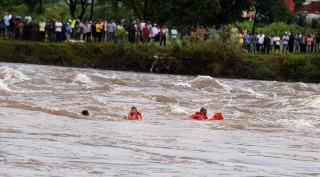 NDRF personnel in the Savitri river after their boat tumbled during a rescue operation. (PTI) NDRF personnel in the Savitri river after their boat tumbled during a rescue operation. (PTI)